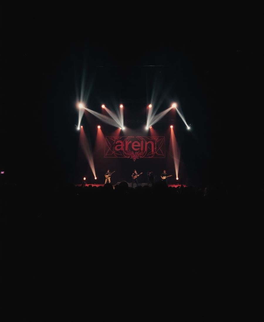 Large arena interior filled with an audience under warm spotlights
