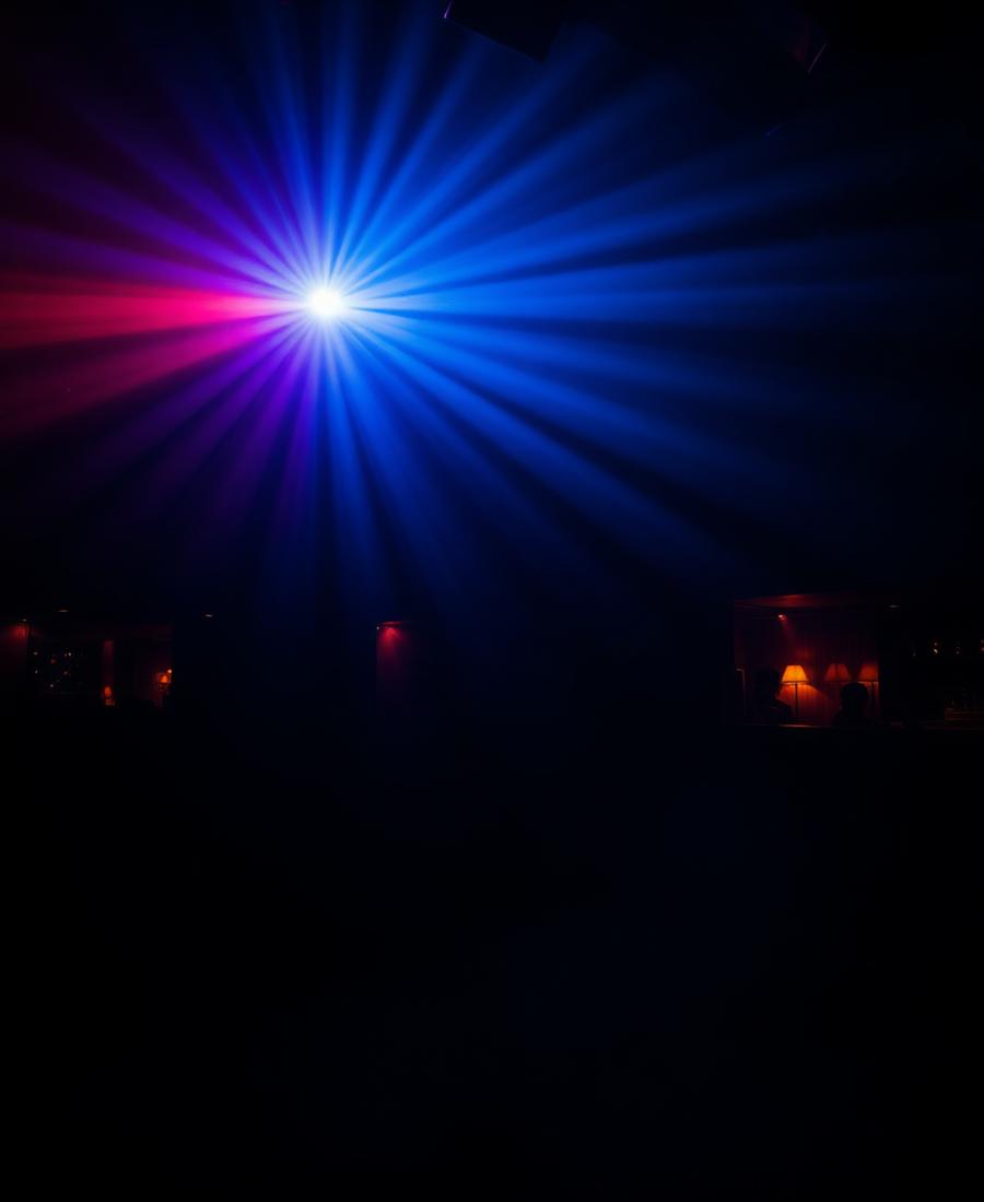 Dark nightclub dance floor with warm lighting and moving crowd